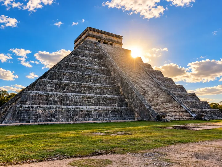 El Castillo pyramid with the sun behind its edge.