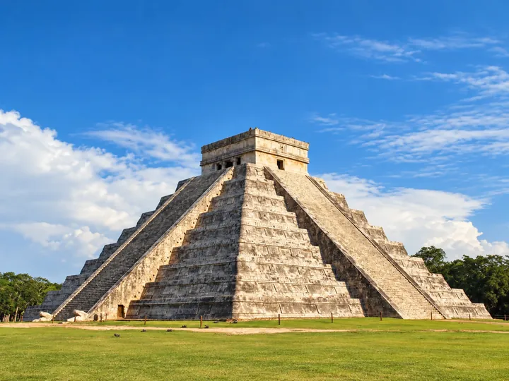 Complete El Castillo pyramid at Chichen Itza, preserving its exact architecture, stairs, viewpoint, vegetation and sky.